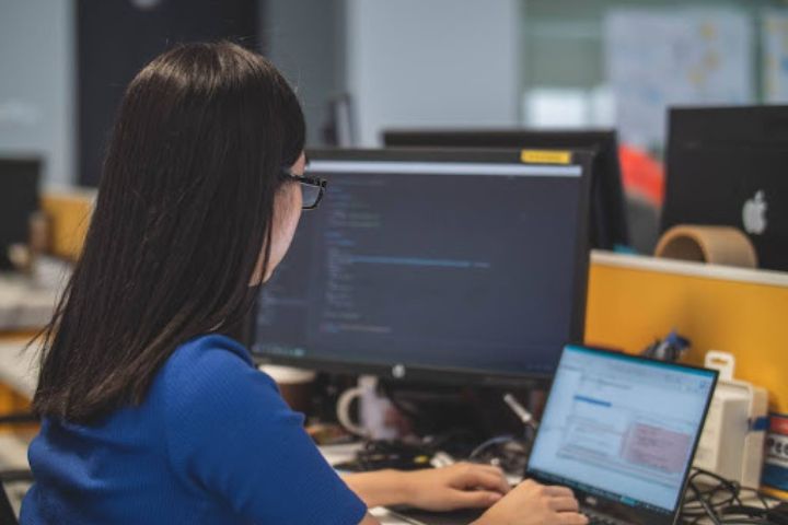 A woman in an office researching newsletter software on her computer